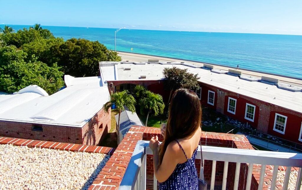 Work and Travel: Living in Key West, Florida 2 woman stands on patio by ocean explaining the work and travel program in key west