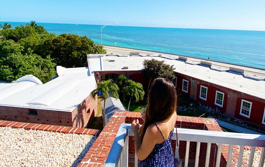 Work and Travel: Living in Key West, Florida 1 woman stands on patio by ocean explaining the work and travel program in key west